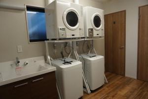a bathroom with two washing machines and a sink at Stella Casa in Gotemba