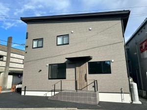 a large brick building with a staircase in front of it at Stella Casa in Gotemba