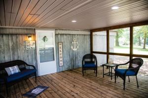 a screened in porch with two chairs and a table at Fisherman's Countryside Escape in Scottsboro +34 photos
