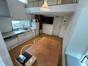 a kitchen and dining room with a wooden table at 塔の宿 宍道湖 in Matsue