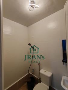 a bathroom with a toilet and a sign on the wall at JRAN's Place Home in Baliuag, Bulacan in Suliban