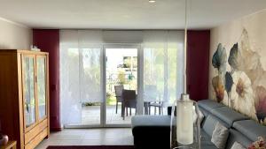 a living room with a couch and a sliding glass door at Stadtwohnung am Oertelplatz in Munich +16 photos