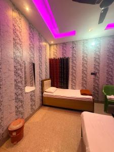a room with a bed and a purple lighting at Vijay palace 850 meter away from Ram mandir in Ayodhya +13 photos