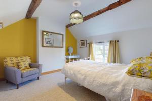 a bedroom with a bed and a chair and a window at The Winners Enclosure - Country Flat Above a Village Pub in Shrewsbury