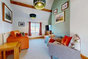 a living room with two couches and a table at The Winners Enclosure - Country Flat Above a Village Pub in Shrewsbury