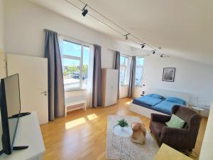 a living room with a blue bed and a couch at Apartment am Rohrbach in Friedrichshafen