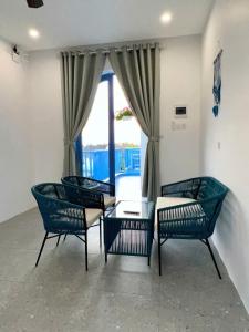 a room with four chairs and a table and a window at Laco Villa in Danang