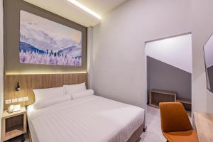 a hotel room with a bed and a tv at Front One Budget Hotel Tirtonadi Solo in Solo