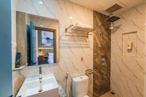 a bathroom with a sink and a toilet and a mirror at Front One Budget Hotel Tirtonadi Solo in Solo