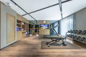 a gym with a treadmill and a chair in a room at Mercure Harbin Central Street Sophia Church in Harbin