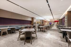 a restaurant with tables and chairs in a room at Mercure Harbin Central Street Sophia Church in Harbin