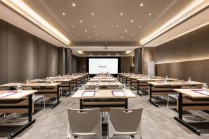 a conference room with desks and a projector screen at Mercure Harbin Central Street Sophia Church in Harbin