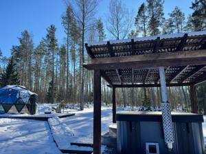a wooden gazebo in the snow with a tent at ForrestVila in Karačiūnai