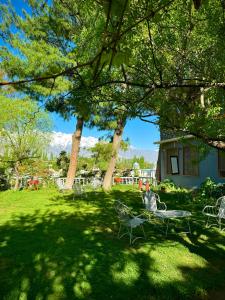 a park with chairs and a table and trees at Northlanders Guest House Skardu in Skardu