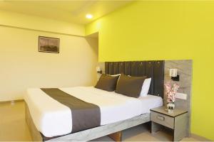 a bedroom with a large bed and a table at FabHotel Vardhan Plaza in Pune