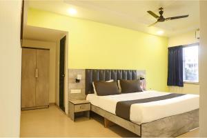 a bedroom with a large bed and a ceiling fan at FabHotel Vardhan Plaza in Pune