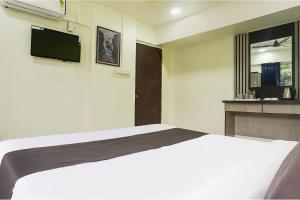 a bedroom with a bed and a tv on the wall at FabHotel Vardhan Plaza in Pune +29 photos