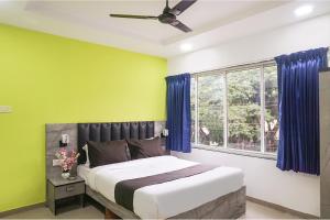 a bedroom with a large bed and a window at FabHotel Vardhan Plaza in Pune