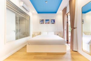 a bedroom with a white bed and a blue ceiling at HUB MULTI 3 HOTEL - Sea & Firework View in Phú Quốc +15 photos
