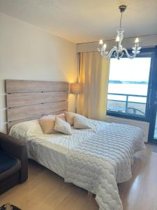 a bedroom with a large bed with a chandelier at Hotelli Terme 111 in Kilvakkala +4 photos