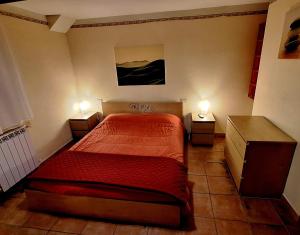 a bedroom with a red bed and two night stands at B&B Nuova Loggia in Fabriano