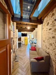 a living room with a couch and a stone wall at B&B Leofreni Natura in Leofreni