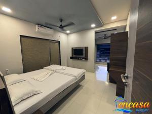 a bedroom with a bed and a tv in it at Encasa Resort in Nagaon