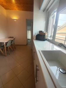 a kitchen with a sink and a table and a window at Piazza di Lefkimmi in Lefkimmi