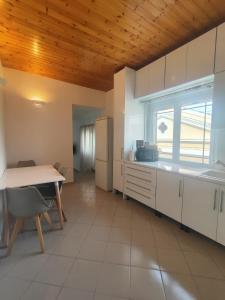 a large kitchen with a table and a refrigerator at Piazza di Lefkimmi in Lefkimmi
