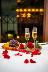 two glasses of wine and flowers on a table at HUB MULTI 3 HOTEL - Sea & Firework View in Phú Quốc