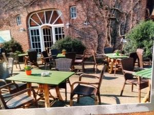 a patio with tables and chairs in front of a brick building at Darpvenner Diele in Ostercappeln