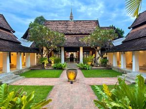 a courtyard of a house with a vase in the middle at Rachamankha Hotel in Chiang Mai