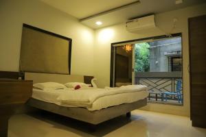 a bedroom with a large bed and a window at Encasa Resort in Nagaon +33 photos