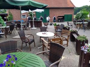 a patio with tables and chairs and people in a building at Darpvenner Diele in Ostercappeln