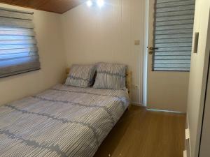 a bed in a small room with a window at La tanière du ptit Lou in Resteigne