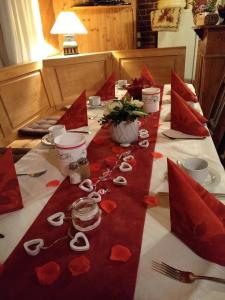 a table with a red table cloth with red flowers on it at Darpvenner Diele in Ostercappeln