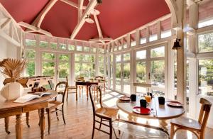 a dining room with tables and chairs and windows at Chambres de charme avec piscine - Le Monde de Charlie - Proche Vichy in Vichy