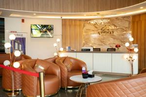 a waiting room with a leather couch and a table at Ascot Hotel in Kozhikode