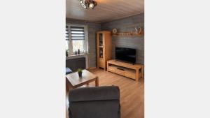 a living room with a television and a chair at Hebels Auszeit in Heimbach