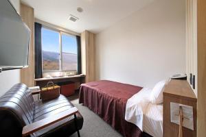 a hotel room with a bed and a window at Gogaku Hotel in Aso +40 photos