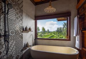 a bath tub in a bathroom with a window at Berlima Boutique Resort in Ubud +34 photos