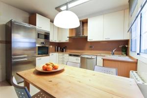 a kitchen with a table with a bowl of fruit on it at Martorell Planet Costa Dorada in Cambrils