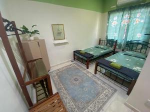 a living room with two beds and a rug at Homestay 3U MU5L1M Only in Cukai
