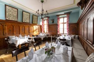 a restaurant with white tables and chairs and a chandelier at Hotel Sailer in Innsbruck