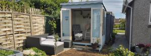 a blue shed with a chair in a garden at Rooms by the Lade Braes & Doocot in St Andrews in St. Andrews