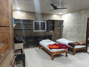 a room with two beds and a tv in it at Vasavi Homes in Mādhavaram