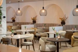 a restaurant with tables and chairs and lights at Hotel & Wellness Zuiver in Amsterdam