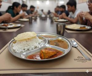 a table with a plate of food with rice at Dreamers Lounge in Trichūr