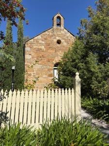 a white fence in front of a church at Roscrow Heritage Retreat in Clare