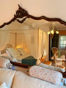 a bedroom with a canopy bed with a large mirror at Ca' Datu in Finale Ligure